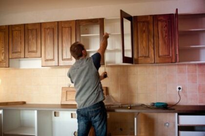 Man installing wooden cabinets.